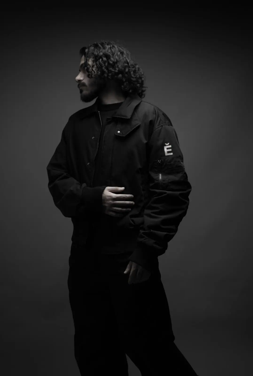 SOUL in profile, black and white, hand resting at his waist