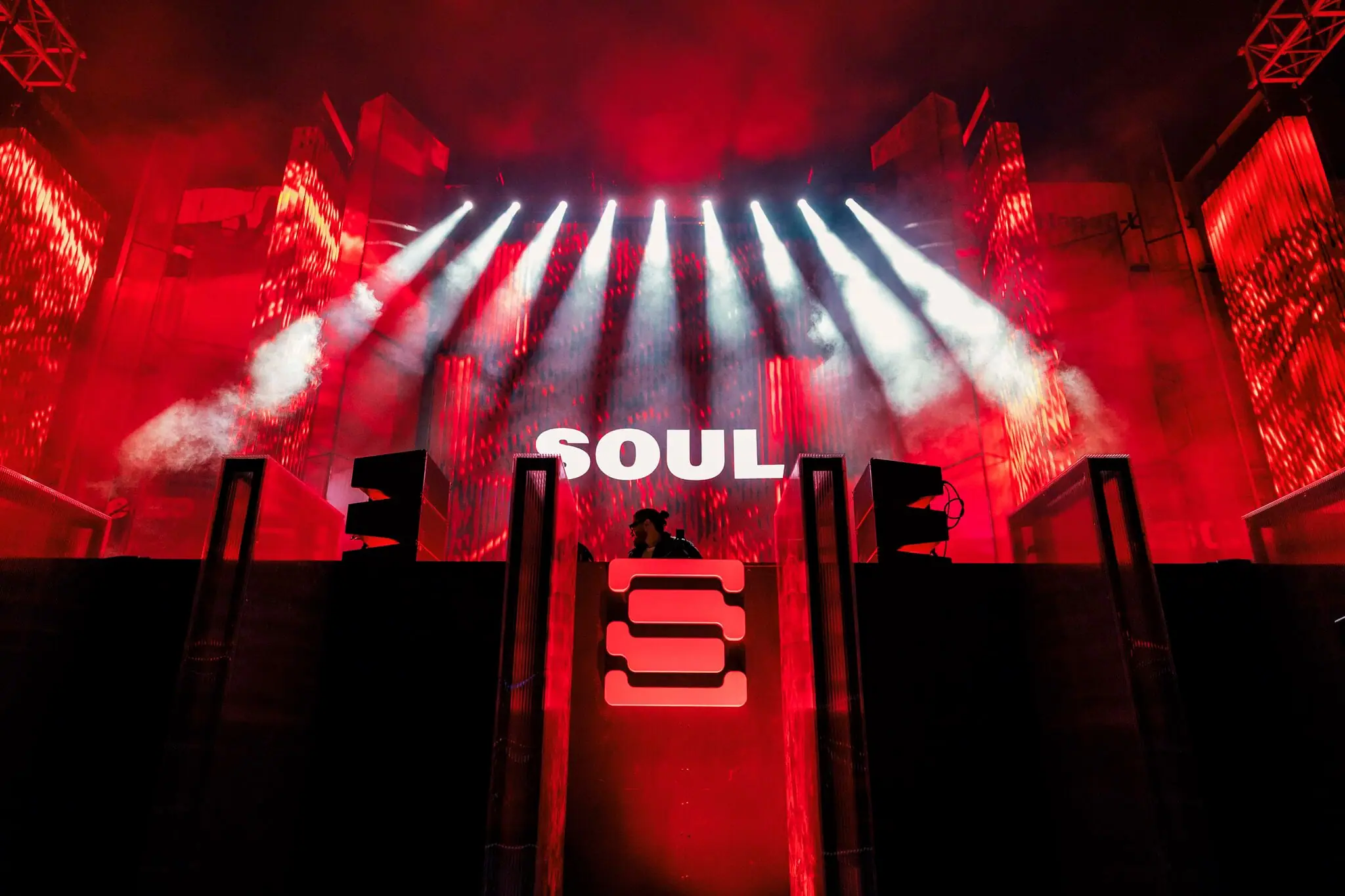 A festival stage lit red, beams fanning over the crowd, SOUL's name on the LED wall above the booth